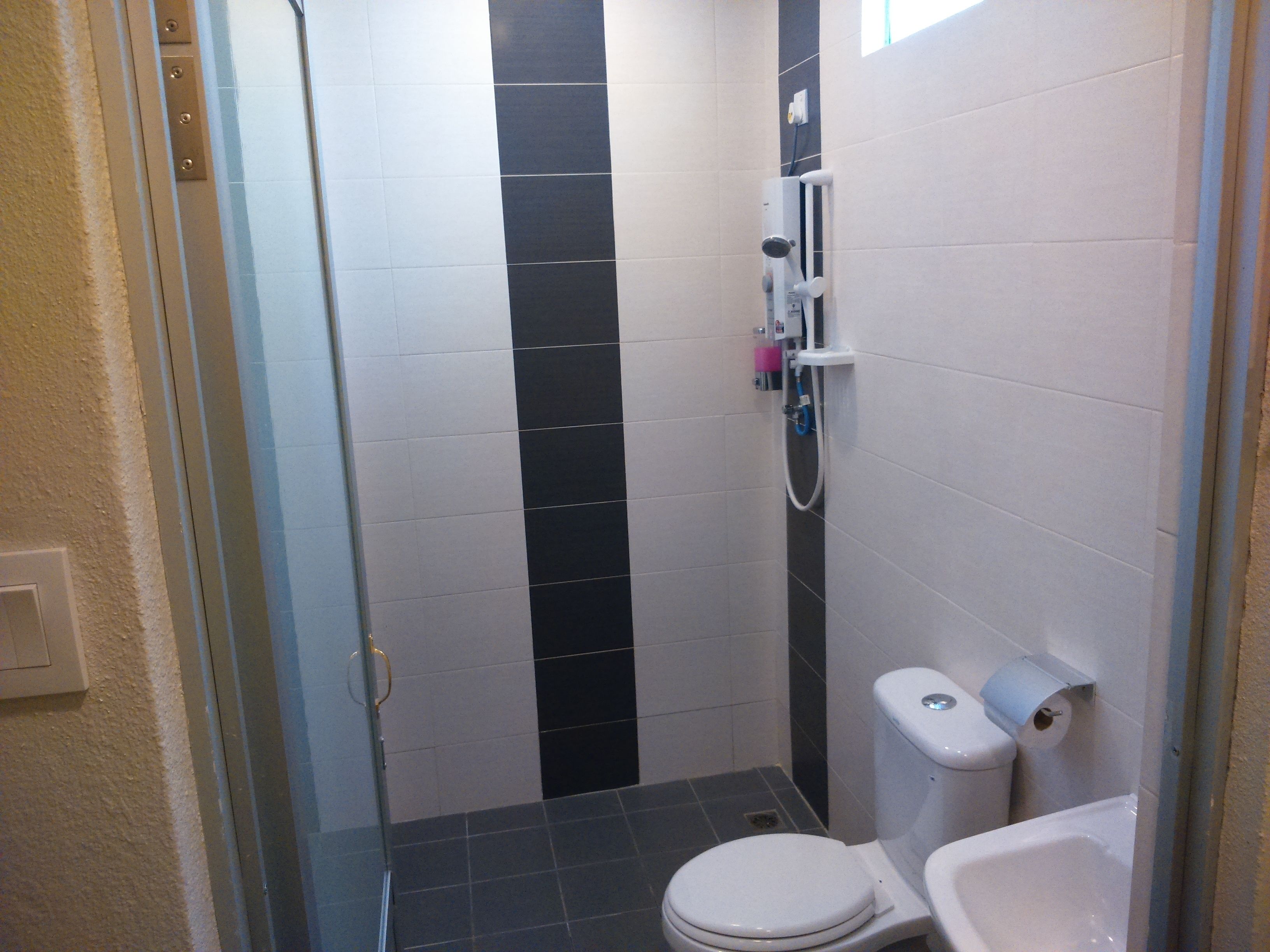 A small bathroom with a toilet, a sink, and a shower.