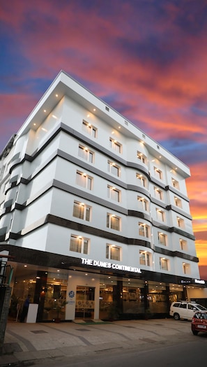 A multi-story hotel with a modern design, featuring a prominent sign for "The Dunes Continental." - The Dunes Continental (Kanayannur)