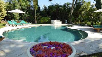 Una piscina al aire libre, tumbonas