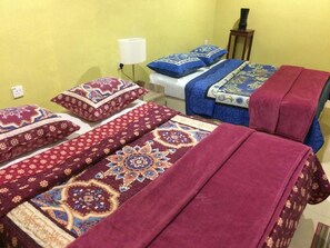 A room with two beds, each covered with patterned blankets and pillows. - Bohok Guest House (Langkawi)