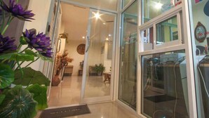 Une entrée d’hôtel moderne avec une porte en verre donnant sur un intérieur bien éclairé.
