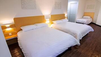 Ein Hotelzimmer mit zwei Betten, Holz-Kopfteilen, weißer Bettwäsche und Wandbildern.
