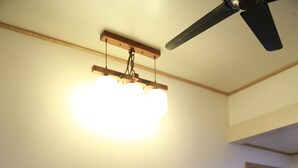 A room with two wicker chairs, a small round table, and a ceiling fan. - Thanks Hotel (Nibong Tebal)