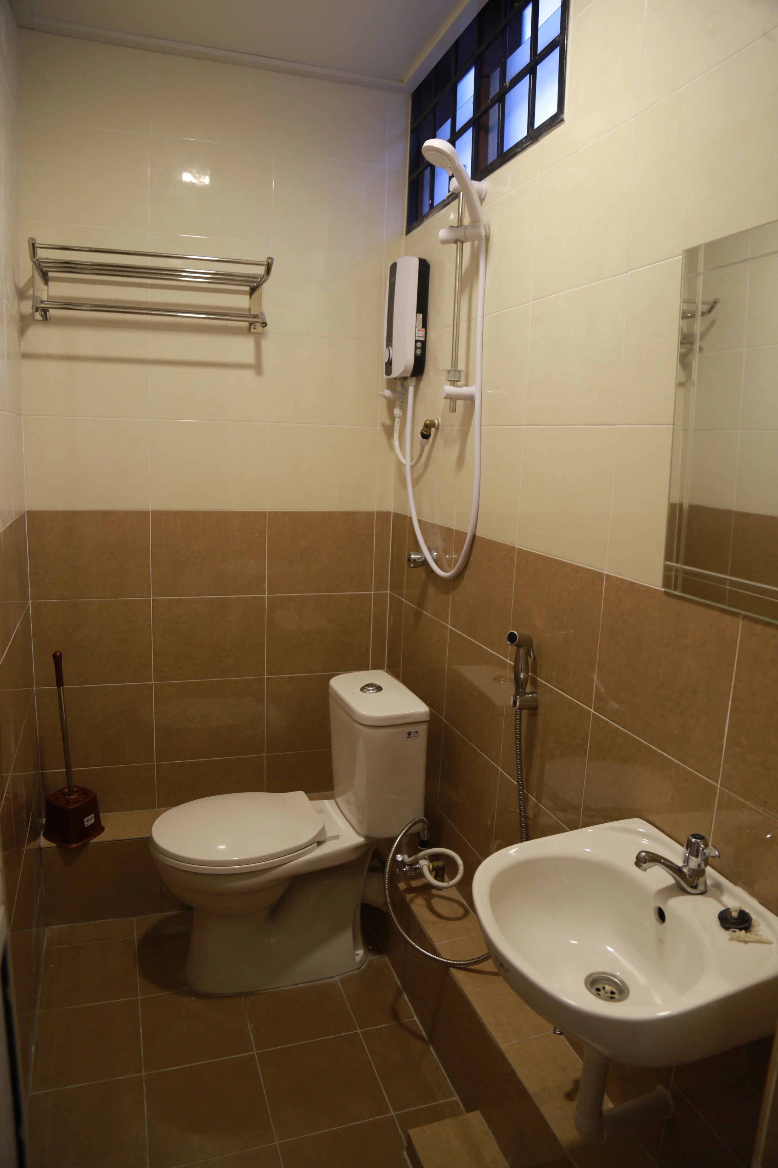 A bathroom with a toilet, sink, and shower.