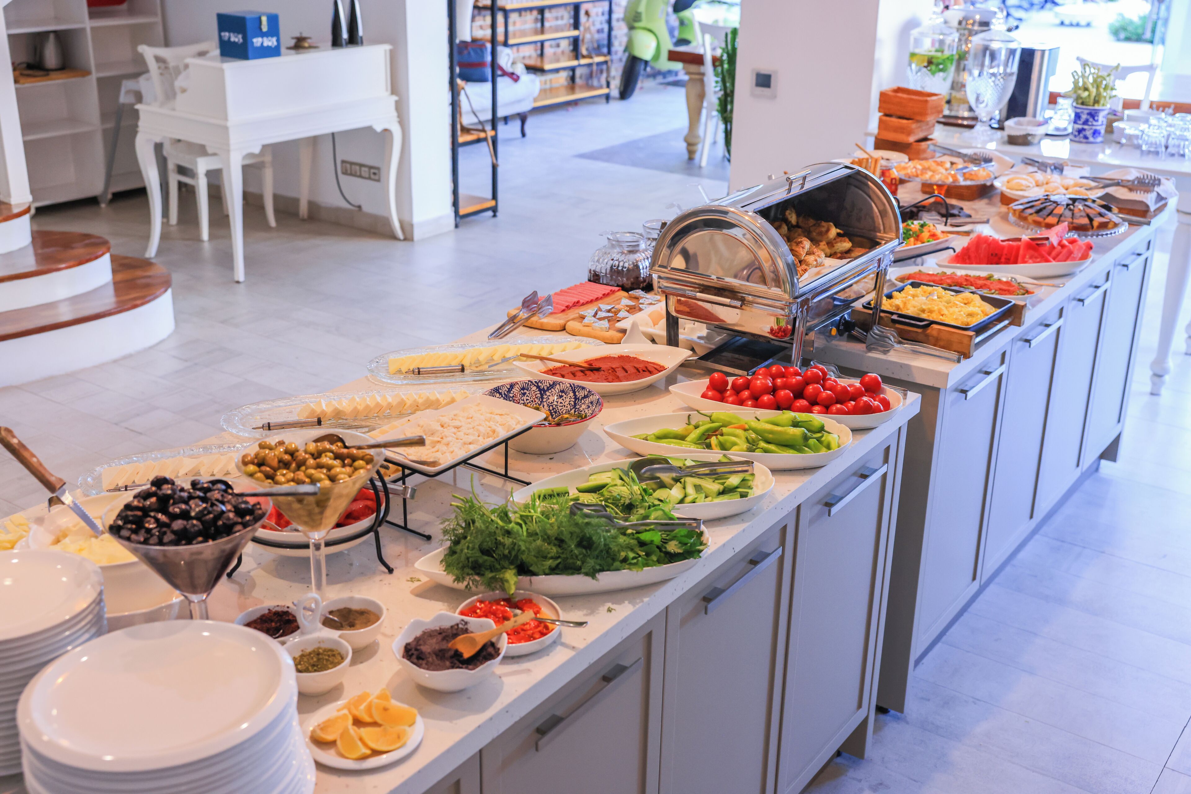 A buffet with various food items and utensils.