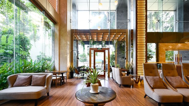 A spacious lobby with a wooden floor, comfortable seating, and large windows offering a view of greenery outside. - Muong Thanh Grand Sai Gon Centre Hotel (Ho Chi Minh City)
