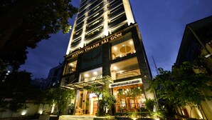 A multi-story building with a bar on the ground floor, surrounded by greenery and illuminated by artificial lighting. - Muong Thanh Grand Sai Gon Centre Hotel (Ho Chi Minh City)