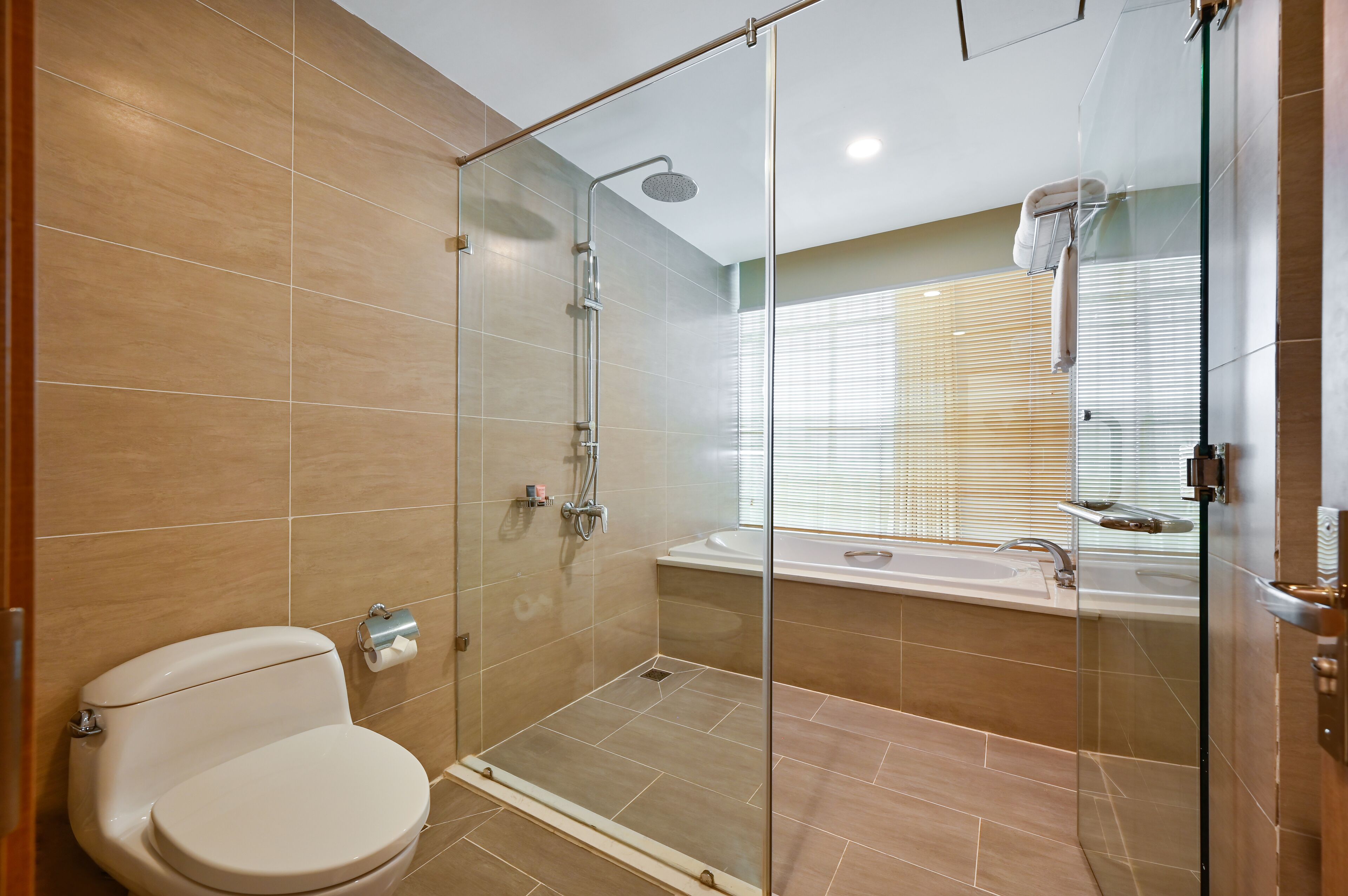 Ein modernes Badezimmer mit einer Glasdusche, einer Toilette und einer Badewanne.