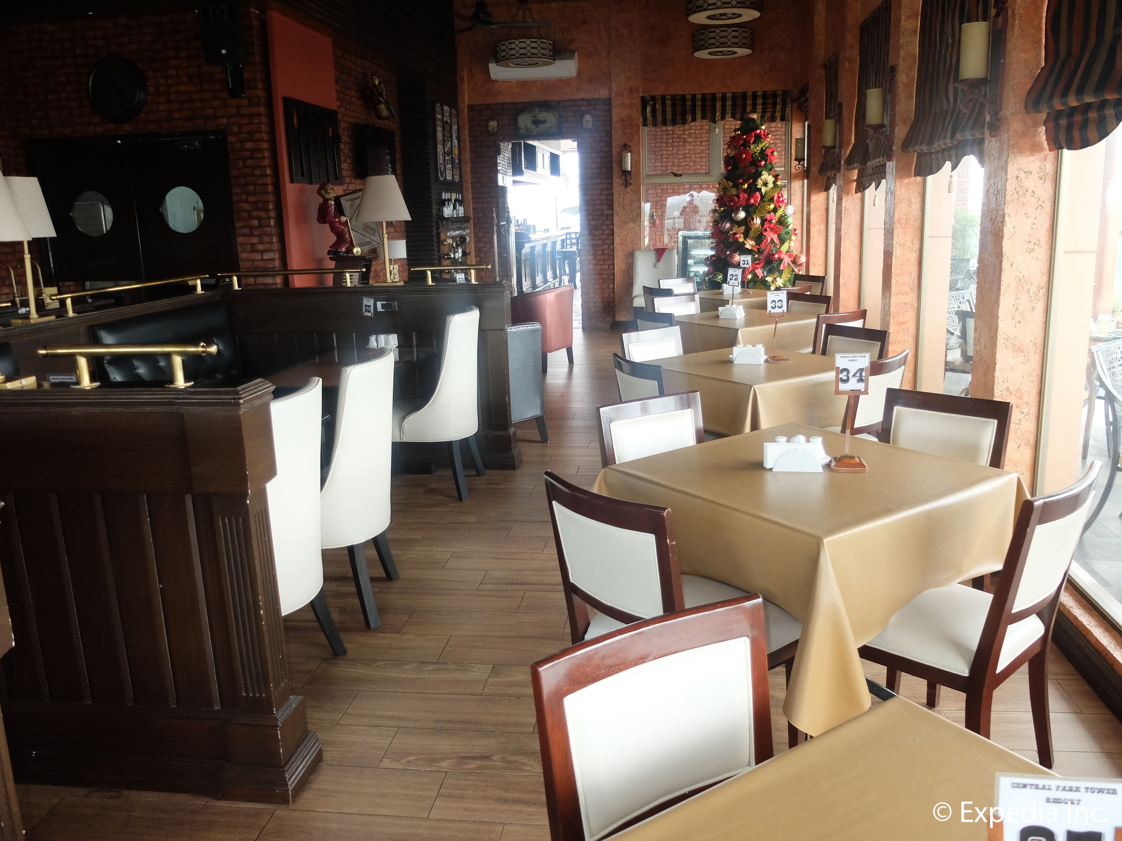 A restaurant with booths and tables, brick walls, and a Christmas tree.