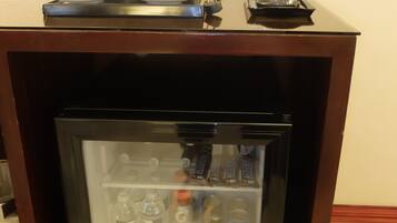 A minibar with a selection of beverages and snacks.
