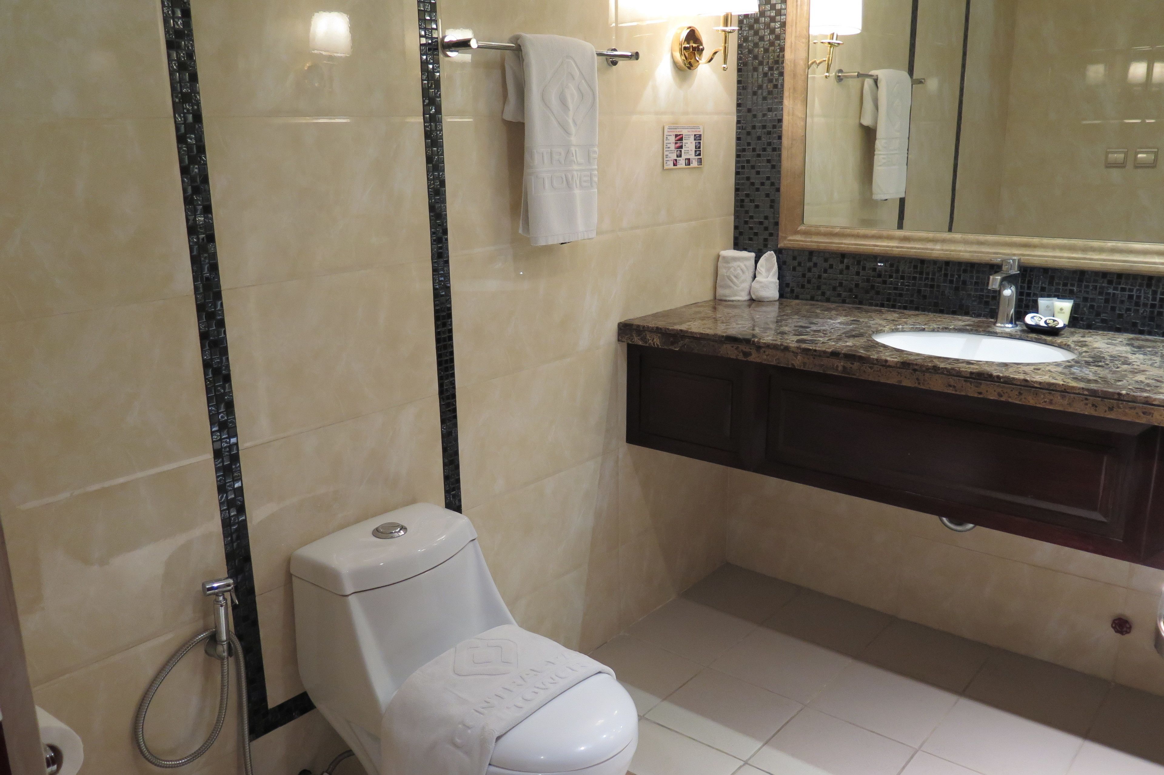 A modern bathroom with a toilet, sink, and shower.