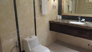 A modern bathroom with a toilet, sink, and shower.