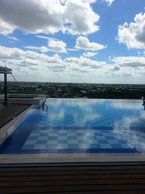 An infinity pool with a checkered pattern, surrounded by a wooden deck.