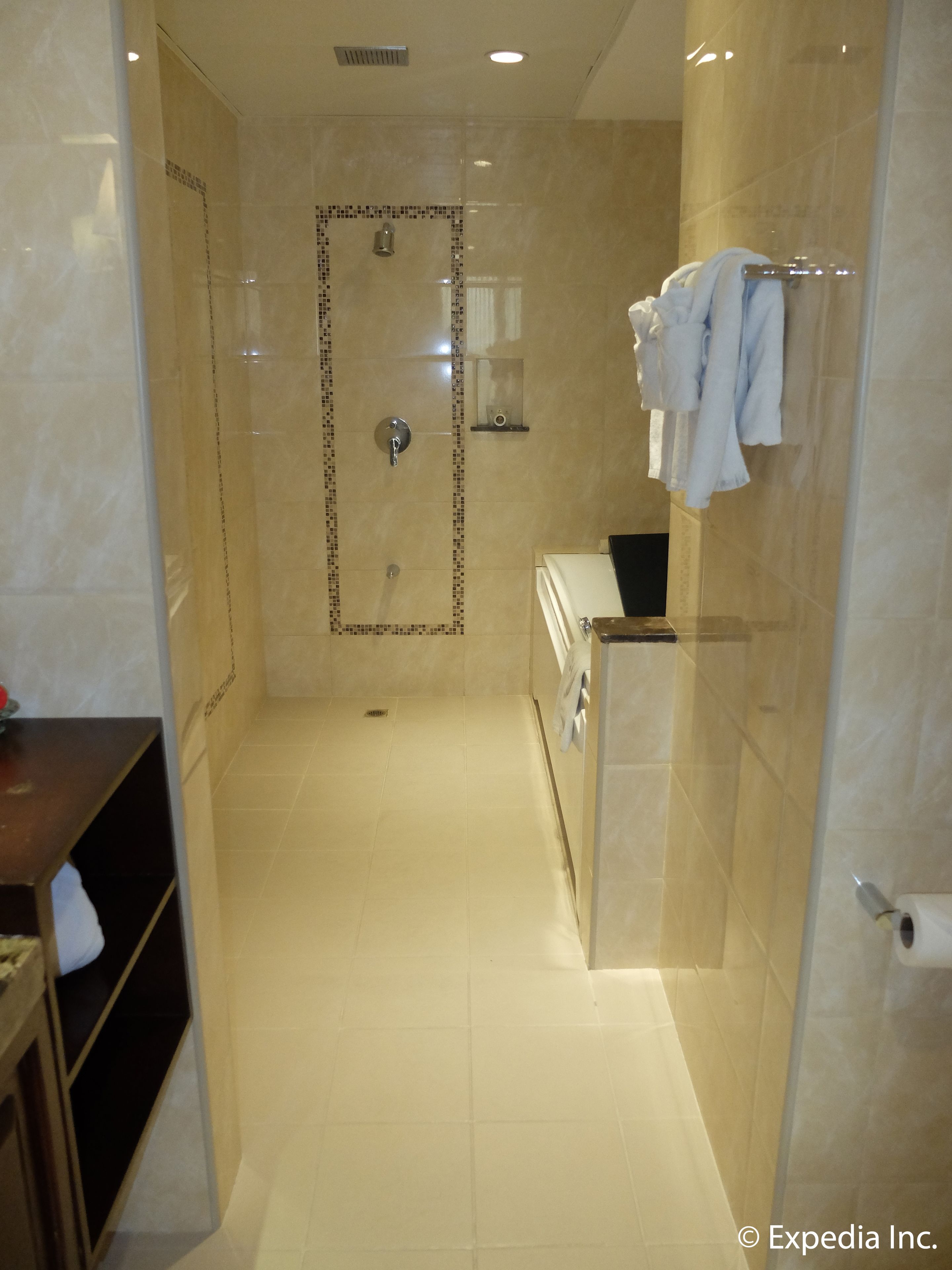 A modern bathroom with a walk-in shower, a vanity with a mirror, and a towel rack.