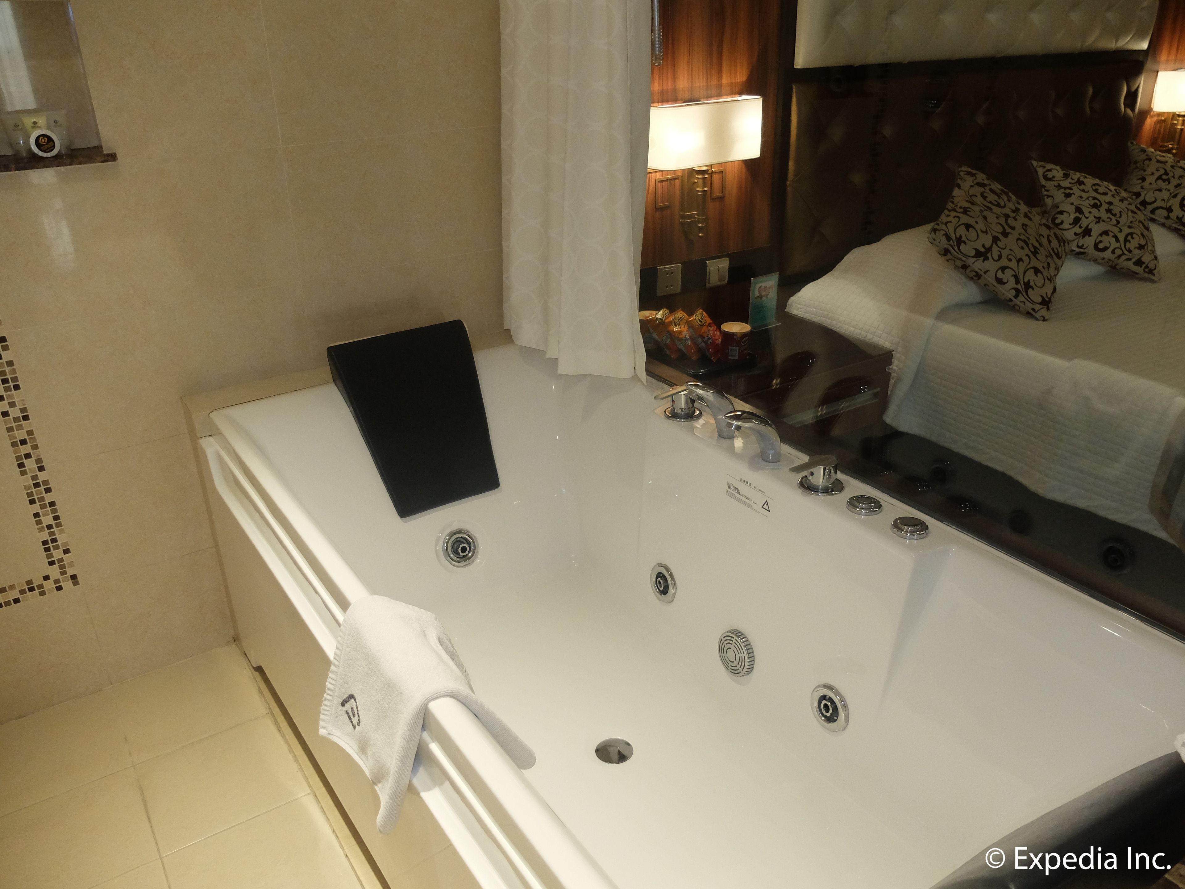A modern bathroom with a large bathtub, a towel rack, and a shower area.