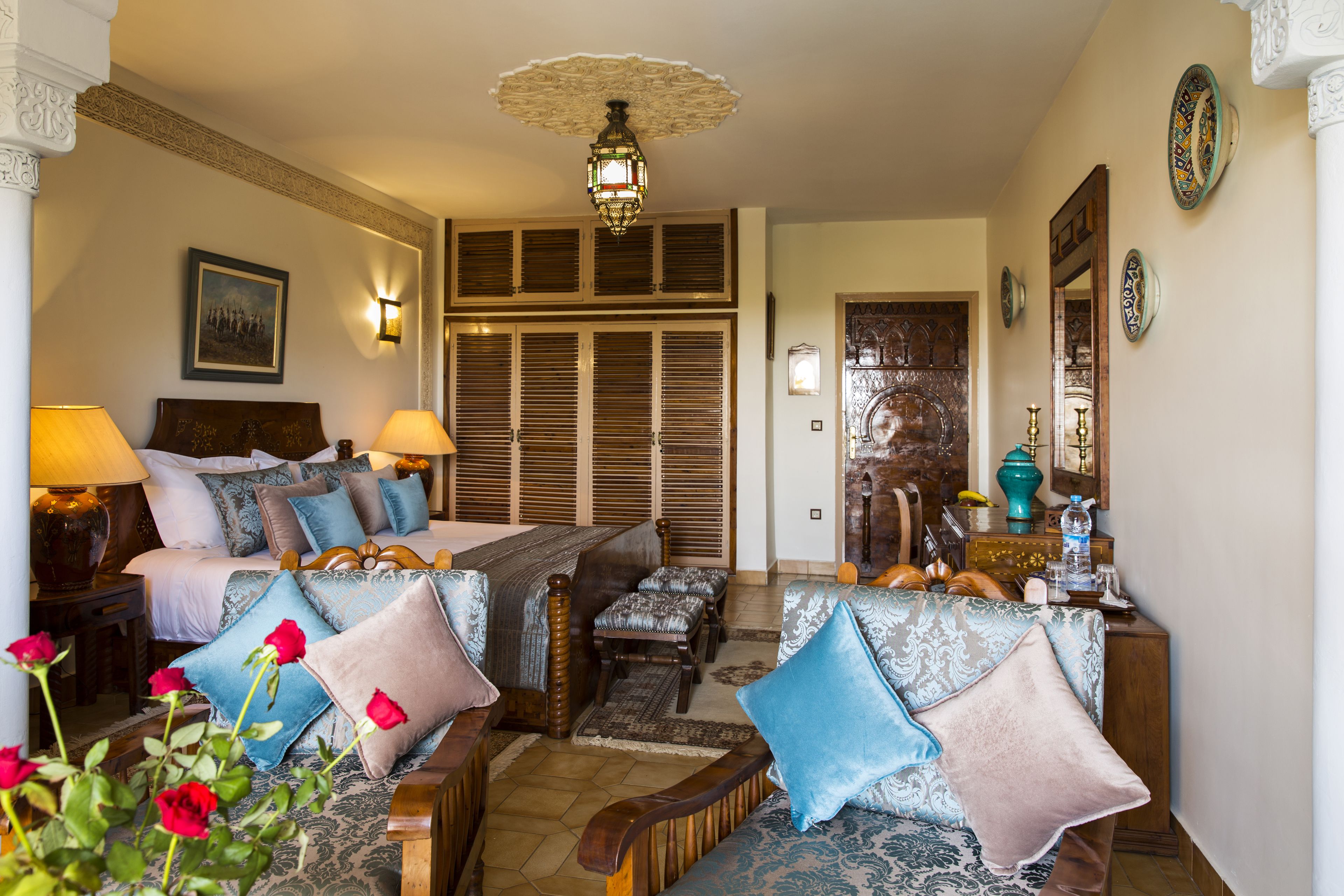 Ein Hotelzimmer mit einem Bett, zwei Sofas, einem Schreibtisch und einem Spiegel.