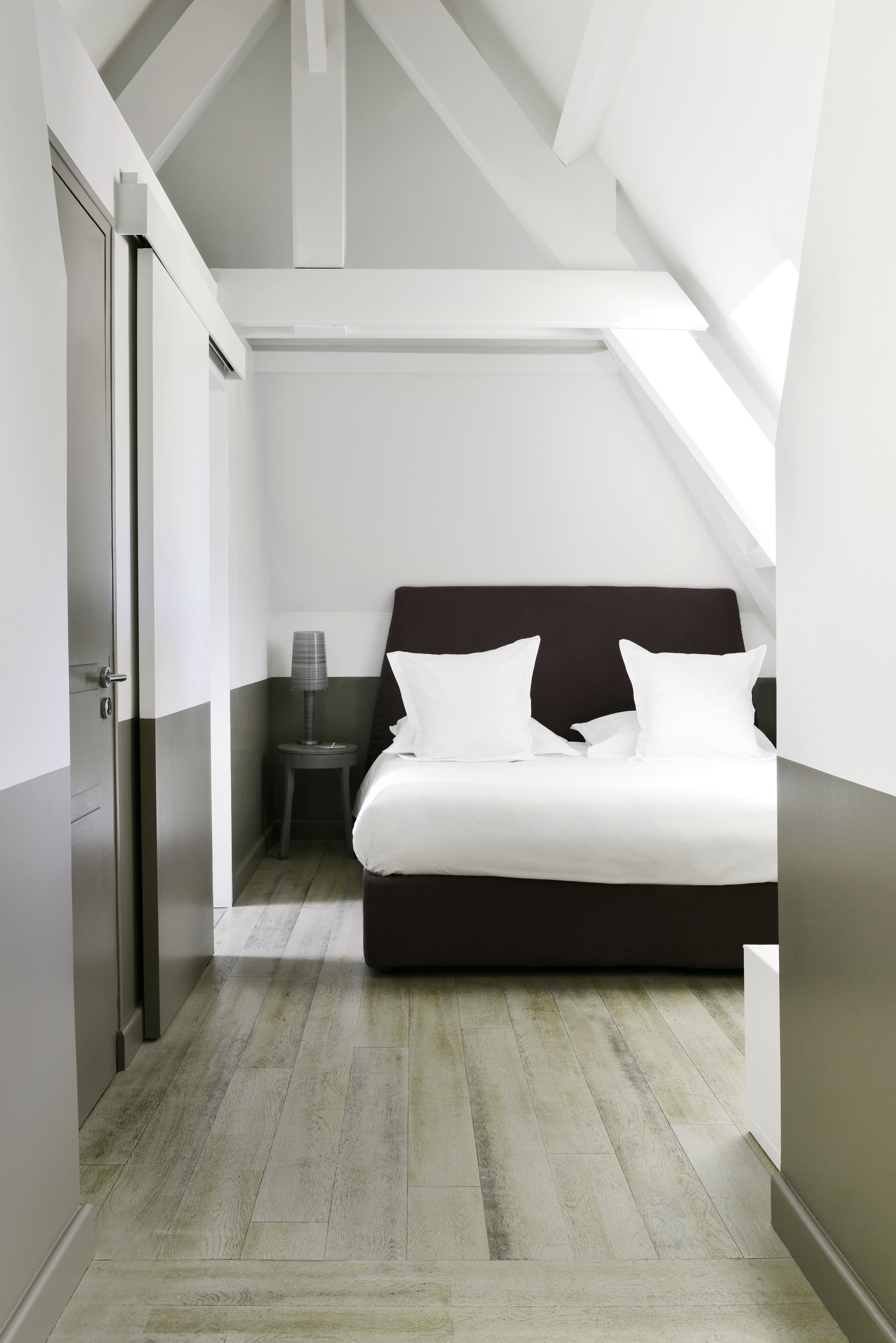 Une chambre à coucher avec un lit, une table de chevet et une lampe.