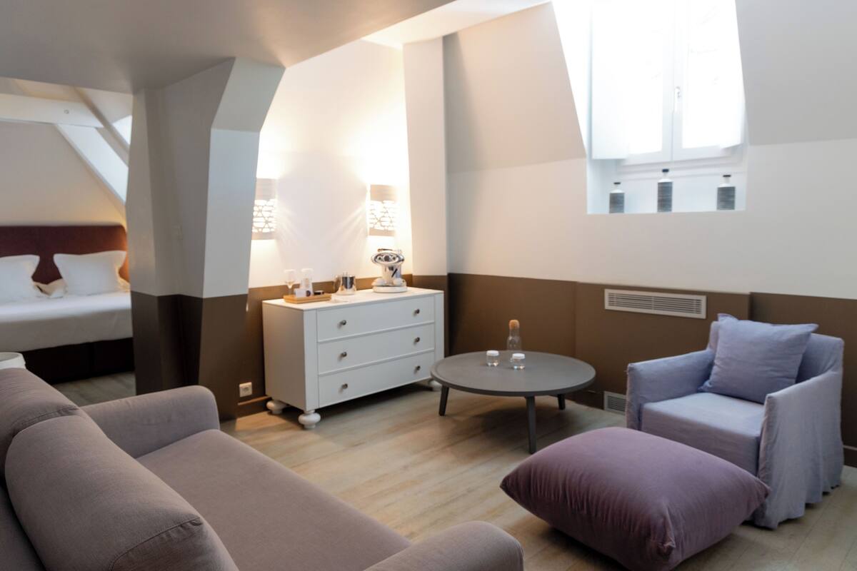 Een moderne woonkamer met een bank, een fauteuil, een bijzettafeltje en een dressoir.