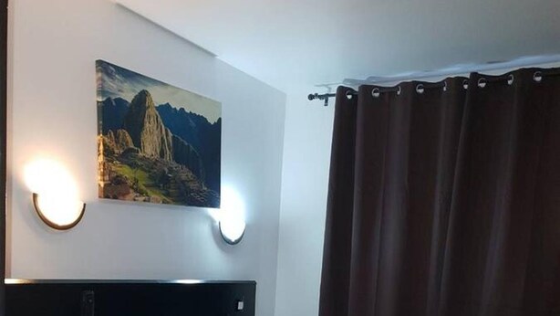 A hotel room with two beds, a painting on the wall, and a curtain. - Hôtel Victory (Marseille)