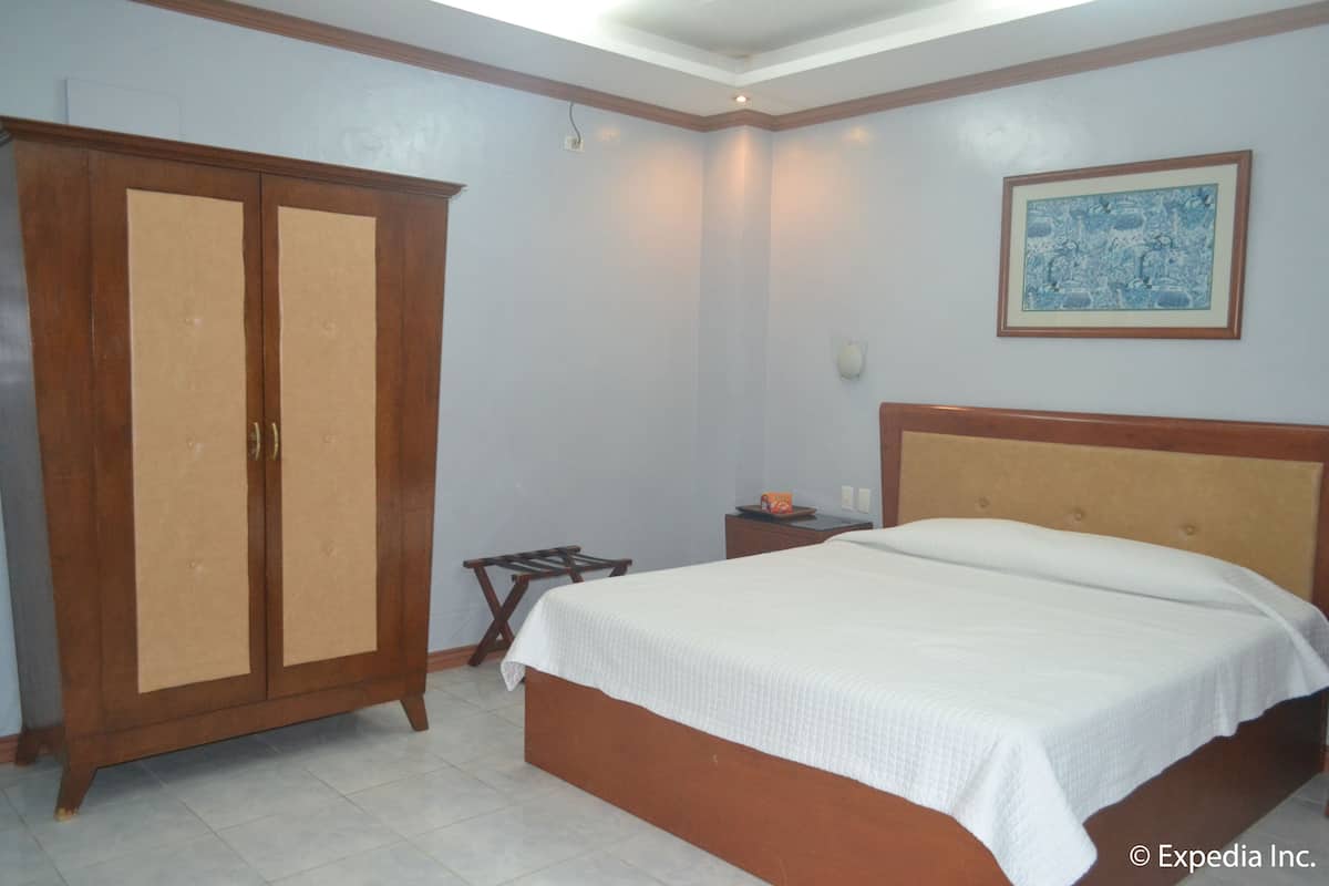 Un dormitorio con cama, armario y mesita de noche.