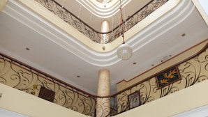 Um interior em vários níveis, com grades ornamentadas e teto decorativo.