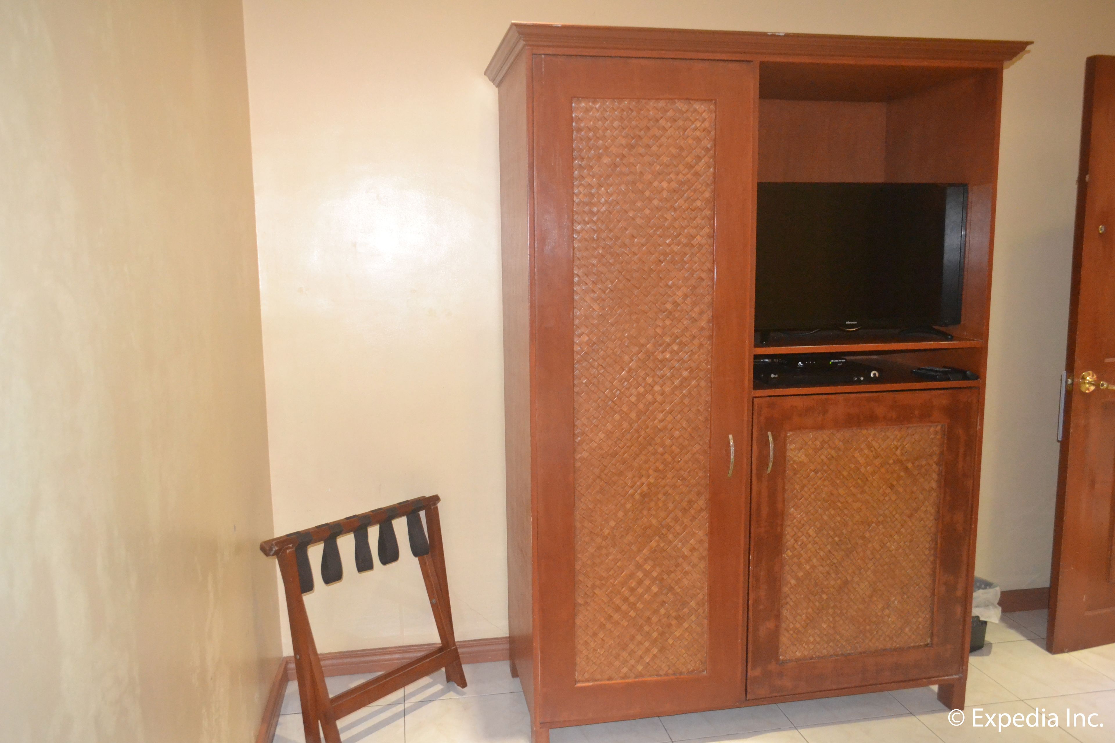 Un mueble de madera con un televisor y una pequeña silla.
