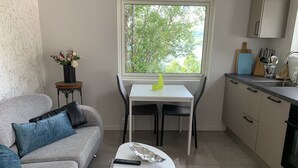 Una cocina moderna con una mesa de comedor, un sofá y un ventanal con vistas a árboles.