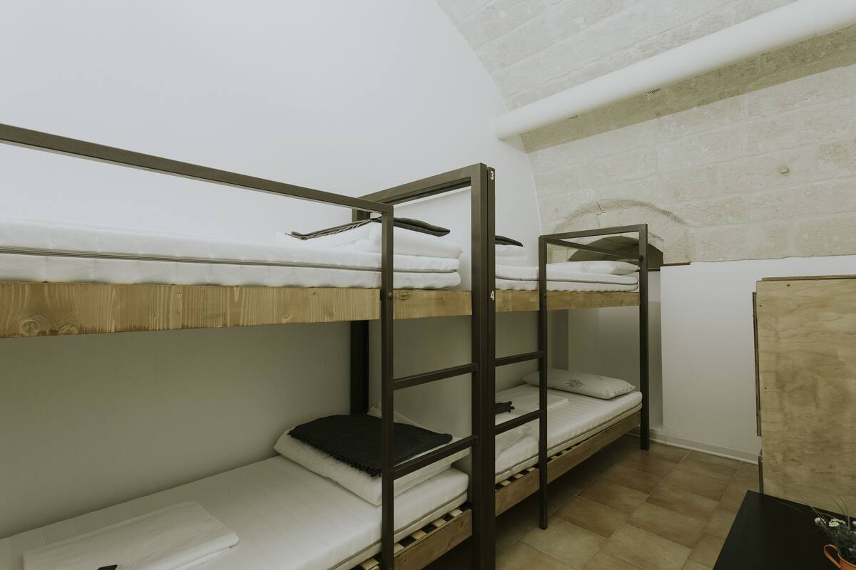 A bunk bed room with a wooden floor and white walls.