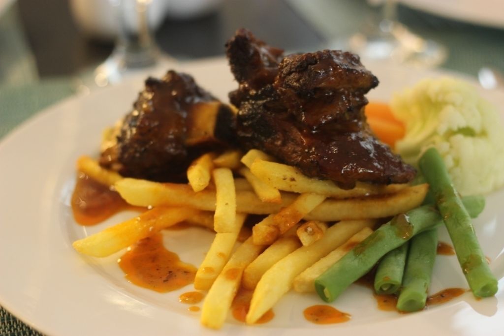 A plate of food with steak, fries, and green beans.