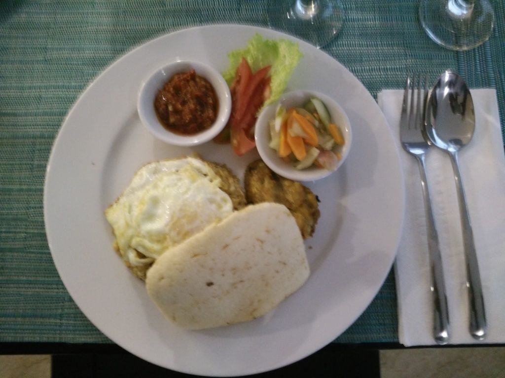A plate with food items including an egg, a piece of fried chicken, and a salad.
