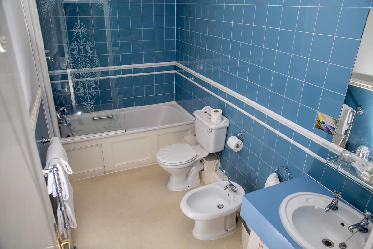 Un baño con bañera, inodoro, bidé y lavamanos.