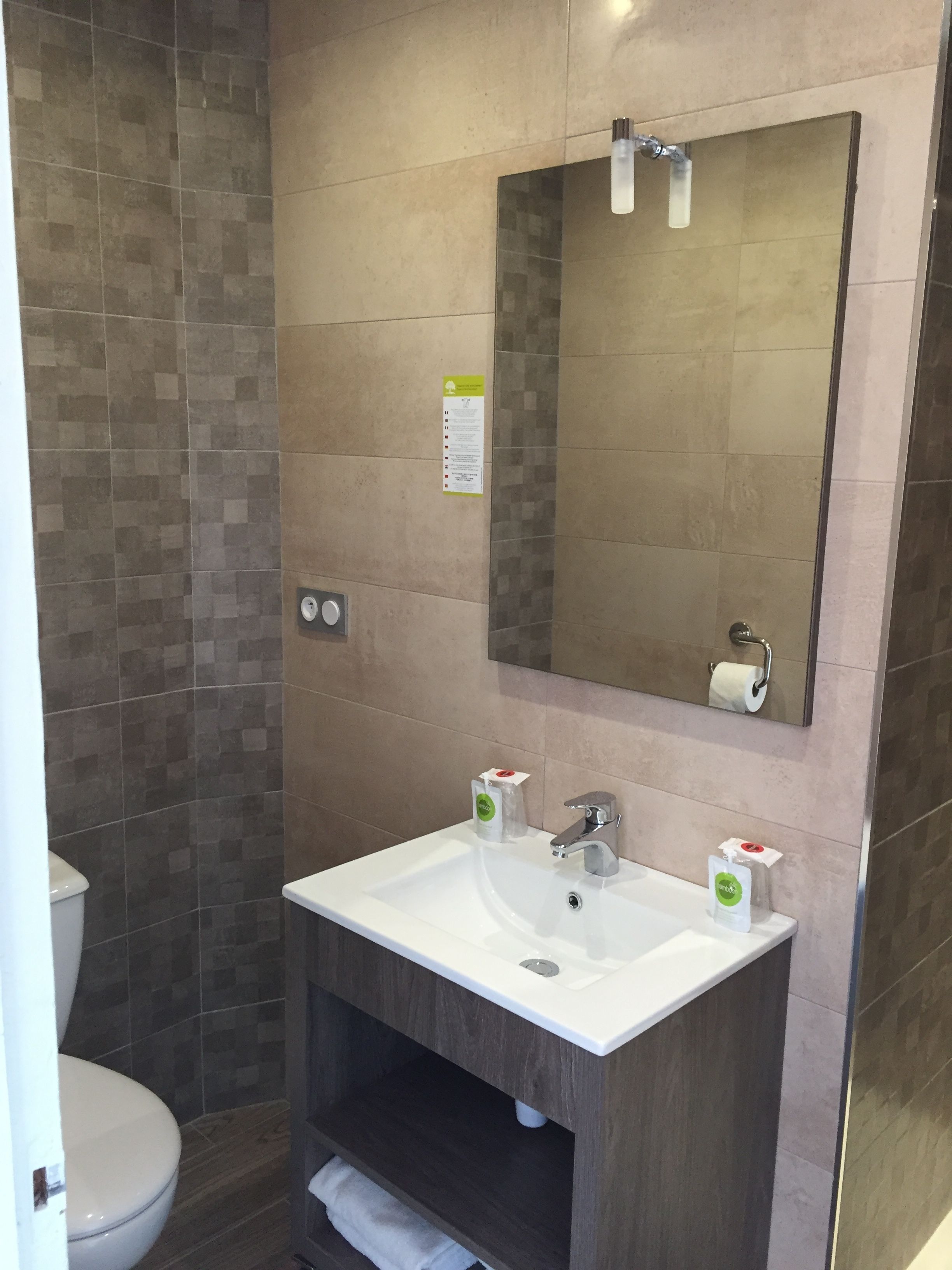 A bathroom with a white sink, a mirror, and a toilet.