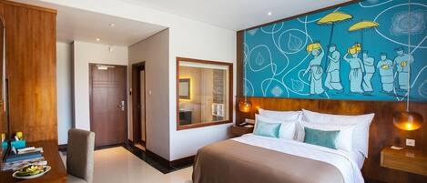 Una habitación de hotel moderna con una cama grande, un escritorio con una silla y una pared con un diseño abstracto azul.