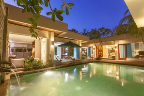 A modern hotel with a swimming pool, outdoor seating, and a well-lit interior. - The Leaf Jimbaran (Jimbaran)