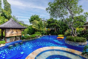 Una piscina al aire libre, camas de piscina gratis, sombrillas