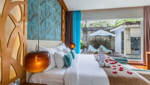 A hotel room with a large bed, a view of the outdoor area, and a balcony with a table and chairs. - The Leaf Jimbaran (Jimbaran)