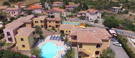 A residential area with houses, a swimming pool, and a parking lot.