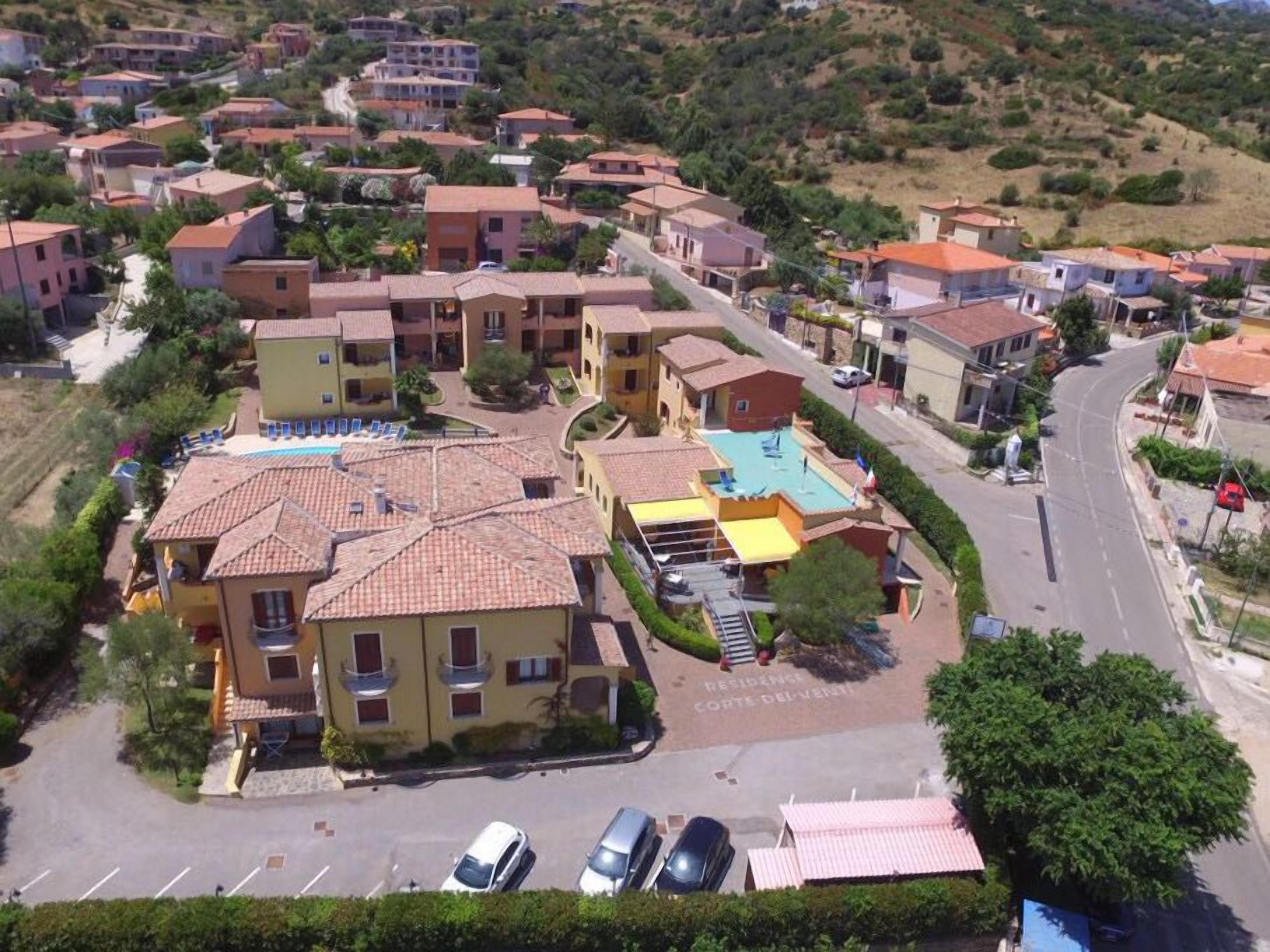 A residential area with multiple two-story buildings, a swimming pool, and a parking lot.