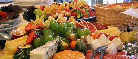 A charcuterie board with various cheeses, meats, fruits, and vegetables.