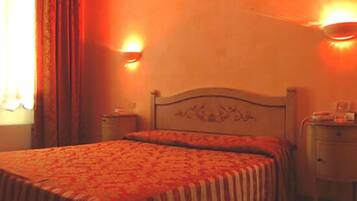 A hotel room with a bed, two bedside tables, and two wall-mounted lamps.
