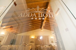 Interior de un hotel con comedor, techo de madera y un cartel que dice "ADDA HOTEL".