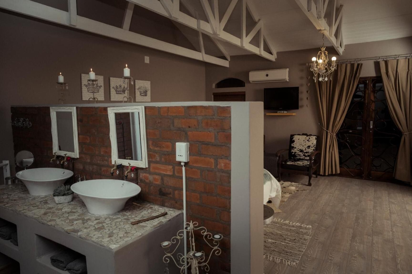 A bathroom with two sinks, a mirror, and a chandelier.