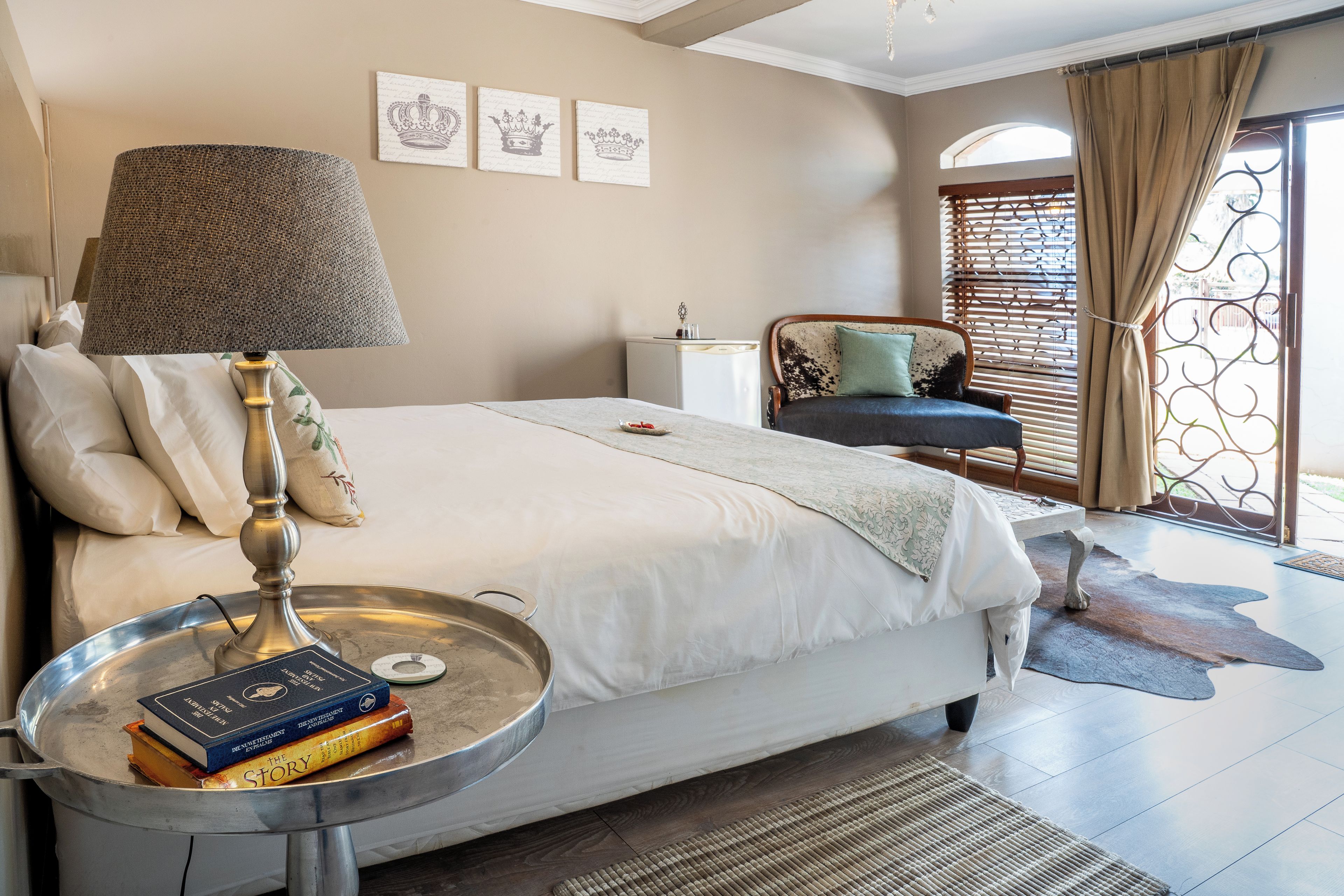 A bedroom with a bed, bedside lamp, books, and a decorative tray.