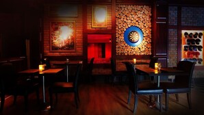 A dimly lit restaurant with brick walls, a dartboard, and a display of hats. - Fourteen Again Hotel (Pattaya)