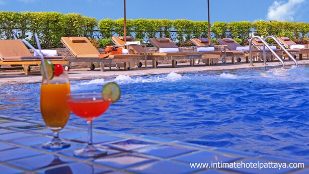 A poolside area with lounge chairs and umbrellas, a clear blue sky, and a website URL at the bottom. - Fourteen Again Hotel (Pattaya)