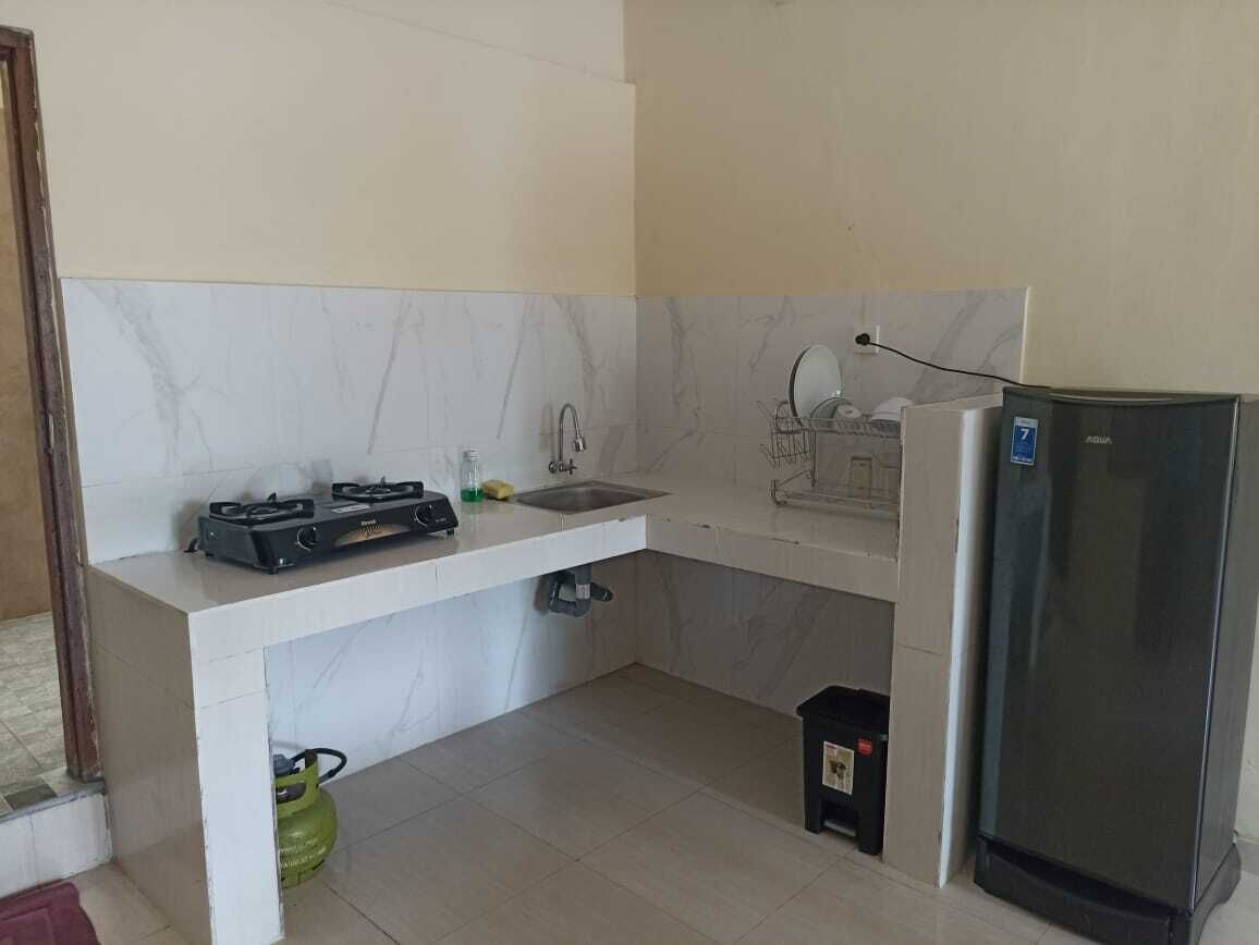 A compact kitchen with a gas stove, sink, and a refrigerator.