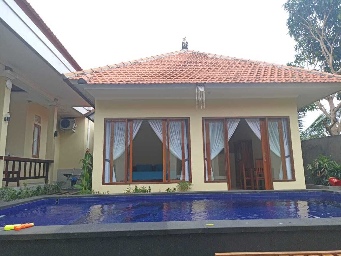 A two-story house with a swimming pool in front.