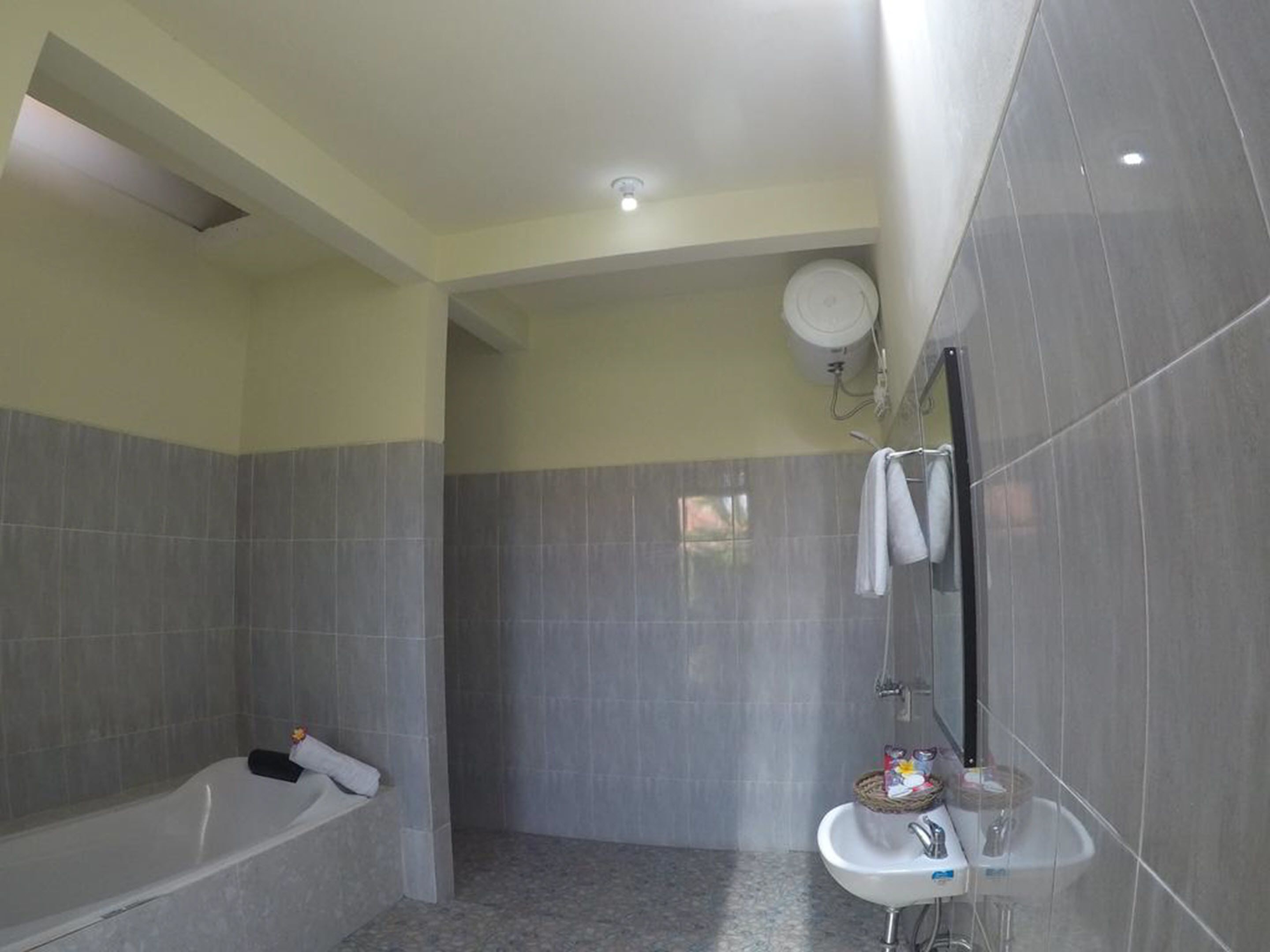 A bathroom with a bathtub, a sink, and a shower area.