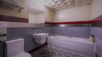 A bathroom with a toilet, sink, and bathtub.