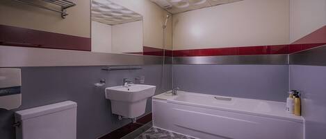 Un baño con inodoro, lavamanos y bañera.